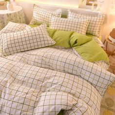 the comforter is made up with green and white plaid sheets, pillows, and pillowcases