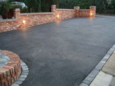 an empty driveway surrounded by brick walls and lights