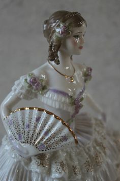 a porcelain figurine with a fan on it's back