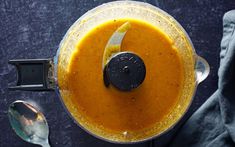 an overhead view of a food processor filled with orange liquid