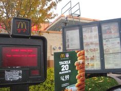 a mcdonald's restaurant sign next to a fast food stand with donuts on it