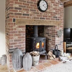 a living room with a brick fireplace and a clock on the wall