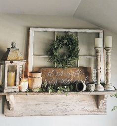 an old window frame with candles and wreath on top