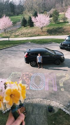 a person standing in the middle of a parking lot with chalk writing on the pavement