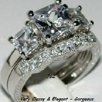 an engagement ring with three princess cut diamonds on top and side stones in the middle