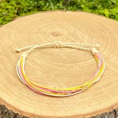 Stylish handmade friendship bracelet, made from loosely braided waxed cord threads in vanilla, pink, white and yellow colors, with decoration small silver lined seed beads. The bracelet fastens with a sliding knot so you can adjust the size to fit perfectly. Minimum diameter when it's closed is 15-16cm. and the fastening threads allows it to be opened to around 28-30cm. The waxed cord thickness is 1mm. If you need specific size please let us know, custom orders are welcome, feel free to contact White Braided Bracelets With Sliding Knot Nylon Cord, White Braided Beaded Bracelets As Gift, White Braided Bracelet With Sliding Knot Nylon Cord, White Braided Nylon Cord Bracelet With Adjustable Length, White Braided Bracelets With Adjustable Length, White Braided Bracelet With Adjustable Length, White Braided Bracelet With Sliding Knot, Pink Adjustable Friendship Bracelets Made Of Nylon Cord, Adjustable Pink Friendship Bracelets Made Of Nylon Cord