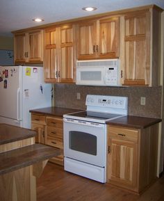 a white stove top oven sitting inside of a kitchen next to wooden cupboards and counter tops