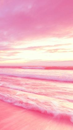 a person riding a surfboard on the beach at sunset