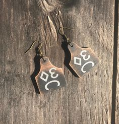 "Custom Cattle Brand Earrings, Personalized Cow Tag Earrings, Wood Western Jewelry -Represent your ranch or farm with these lightweight, cattle tag western earrings. They can be customized with your brand, number, initials, etc. Great gift idea or new go-to earrings for yourself! -They come in your choice of distressed white, natural, distressed black, or dark walnut. Tags measures 1.2\"x1.5\" -Please send a clear brand photo through Etsy messenger. SHIPPING & PROCESSING TIME -Please allow 2 Cow Tag Earrings, Livestock Branding, Cattle Tags, Cow Tag, Glen Rose, Brand Earrings, Cattle Brands, Dog Collar Tags, Earrings Wood