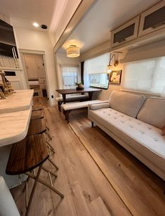 a living room filled with furniture next to a kitchen