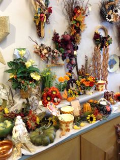 a bunch of flowers that are sitting on a table in front of a wall mounted clock