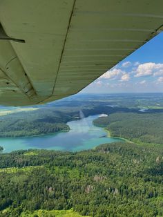 the view from an airplane looking down on a lake and forest area with blue water