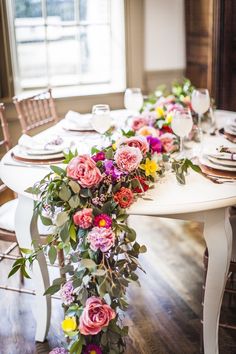 the table is set with flowers and place settings