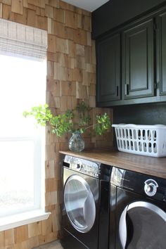 a washer and dryer sitting next to each other in a room with wooden walls