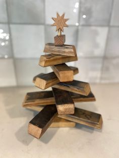 a wooden christmas tree made out of pieces of wood with a star decoration on top