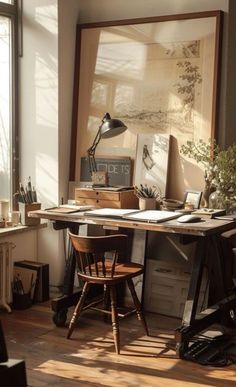 a desk with two wooden chairs in front of a window and a painting on the wall