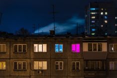 an apartment building with windows lit up at night