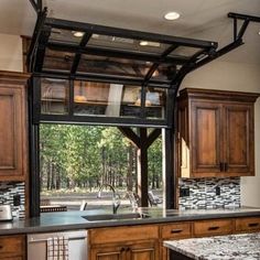 a kitchen with wooden cabinets and granite counter tops under a glass door that opens to the outdoors