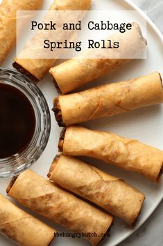 pork and cabbage spring rolls on a white plate next to a cup of black tea