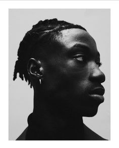 a black and white photo of a woman with dreadlocks on her head, looking off to the side