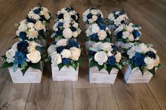 four wooden boxes with white and blue flowers in them sitting on the floor next to each other