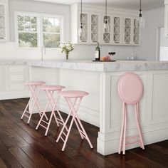 three pink stools sit in front of an island