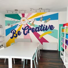 there is a large wall mural in the children's playroom that says be creative