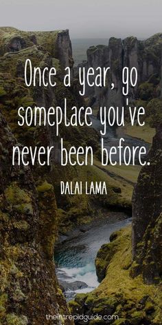 a quote on the side of a mountain saying, once a year, go someplace you've never been before