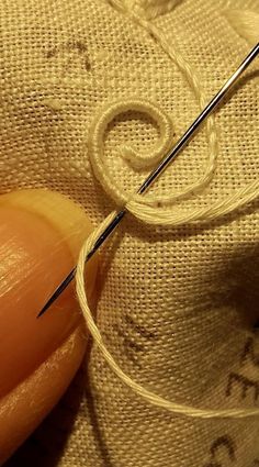 the needle is being used to thread through fabric with two different types of needles on it