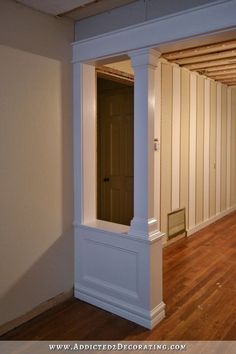 an empty room with wooden floors and white columns in the corner between two walls that have been stripped off