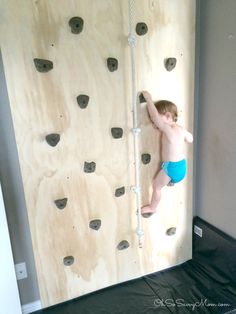 a young boy climbing up the side of a rock wall