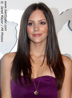 a beautiful young woman in a purple dress posing for the camera with her hand on her hip