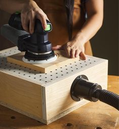 a person using an electric sander on a piece of wood