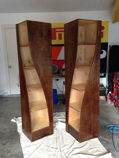 two tall wooden bookshelves sitting in a garage