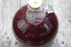 a glass bottle filled with liquid sitting on top of a wooden table