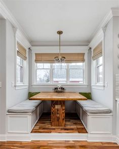 a kitchen with a table, bench and window seat in it's center area