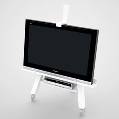 a computer monitor sitting on top of a stand with a keyboard attached to the screen