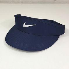 the nike visor is blue and has a white swooish logo on it