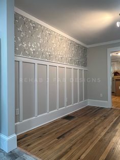 an empty room with wood floors and white paneling on the walls is seen in this image