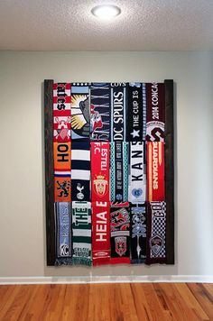 a room with wooden floors and a large painting on the wall above it that has many different types of flags