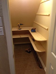 a small room with a shelf and tools in the corner, next to a door