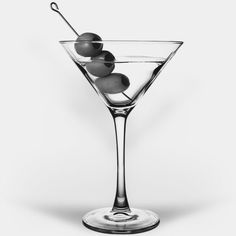 a martini glass with olives in it on a white background, black and white photo