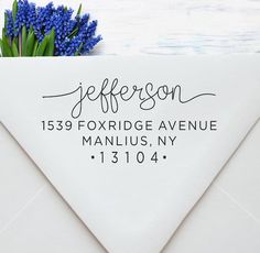 an envelope with a blue flower and address stamp