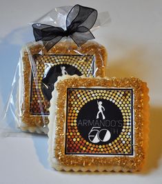 two cookies wrapped in cellophane and decorated with black ribbon