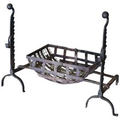 a metal basket holder with two handles on each side and an iron stand underneath it