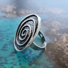 Add a twist to your style with our Silver Swirl Ring, a unique piece that reflects the beauty of boho fashion. Handcrafted in Istanbul, this ring features a mesmerizing spiral design in silver which adds a touch of whimsy - Perfect for those who love to express their individuality. Our Silver Swirl Ring is a large silver ring from our beautiful Anatolian collection, handcrafted in Istanbul by local artisans. Measurements: Length 3.5cm, width 2.5cm (ring size adjustable) Materials: Silver plated Bohemian Spiral Rings As A Gift, Bohemian Silver Swirl Jewelry, Swirl Ring, Authentic Jewelry, Spiral Design, Local Artisans, Zinc Alloy, Unique Pieces, Istanbul