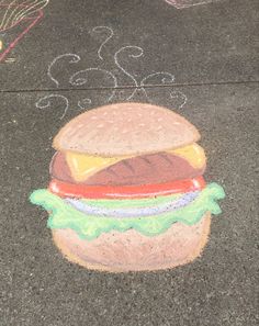 a chalk drawing of a hamburger on the ground next to a child's sidewalk