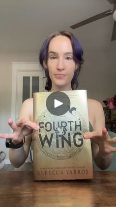 a woman holding up a book in front of her face with the words fourth and wing on it