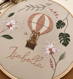 a close up of a embroidery on a hoop with an animal in a hot air balloon