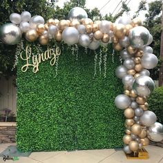 a large balloon arch with silver and gold balloons